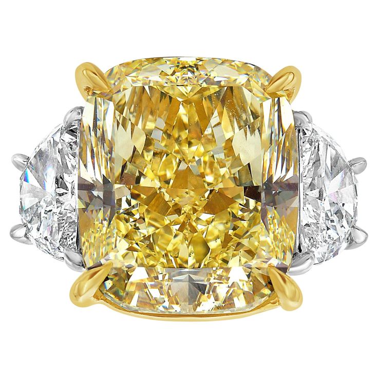 Introducing an extraordinary 16.22 Carat Fancy Yellow Diamond Three Stone Engagement Ring, featuring an elongated cushion cut with internally flawless clarity and GIA certification. This magnificent yellow diamond, renowned for its vibrant color, is perfectly complemented by 1.69 carat E VS+ half moons, bringing the total weight to 17.91 carats. Expertly crafted in platinum and 18k yellow gold, this ring showcases excellent cutting for unparalleled brilliance. Handmade in NYC, this stunning piec Angie Crabtree, Fancy Yellow Diamond Ring, Radiant Diamond Rings, Radiant Cut Diamond Ring, Canary Diamond, Yellow Diamond Ring, Cushion Diamond Ring, Yellow Diamonds Engagement, Cushion Cut Diamond Ring