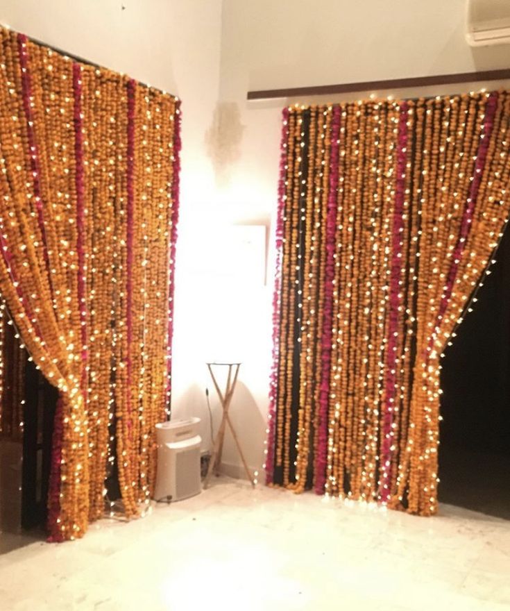 the room is decorated with gold and red beaded curtains, black doors, and a toilet