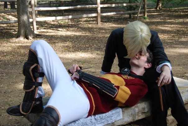 a person laying on top of a wooden bench in the woods next to a fence