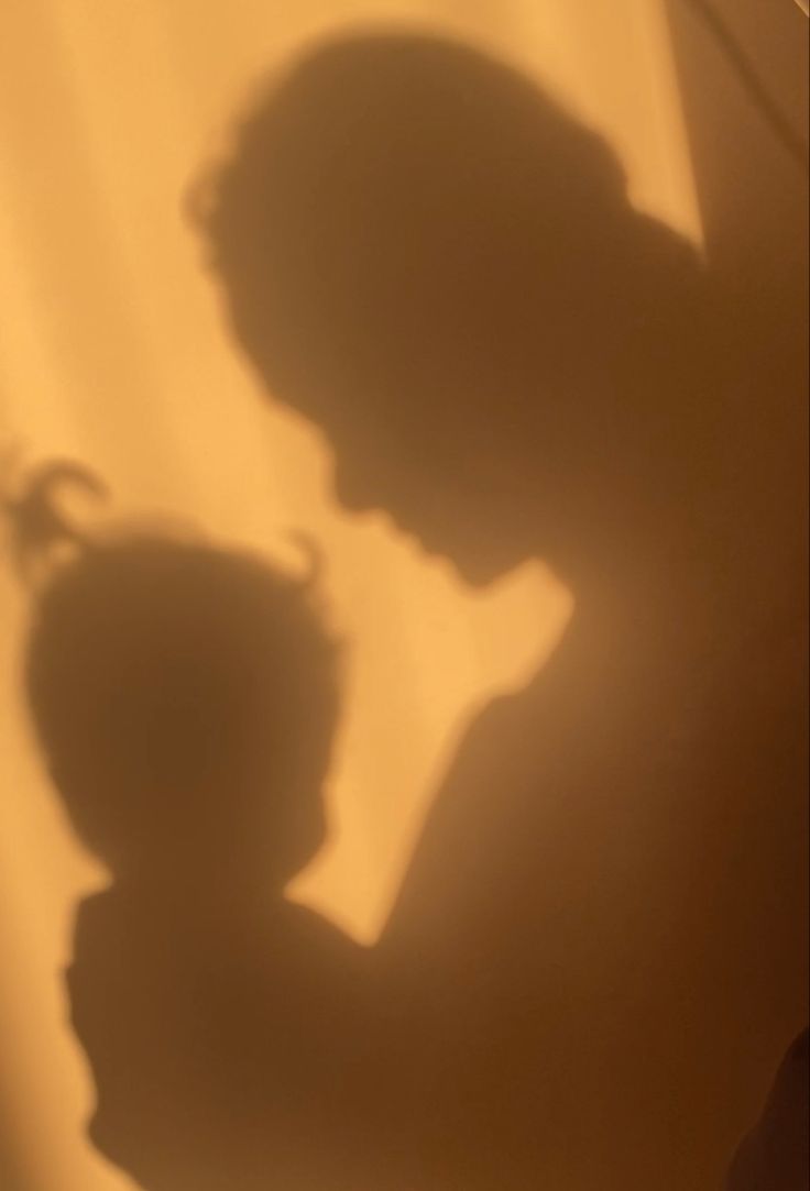 the shadow of a person holding a vase