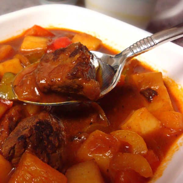 a white bowl filled with stew and vegetables