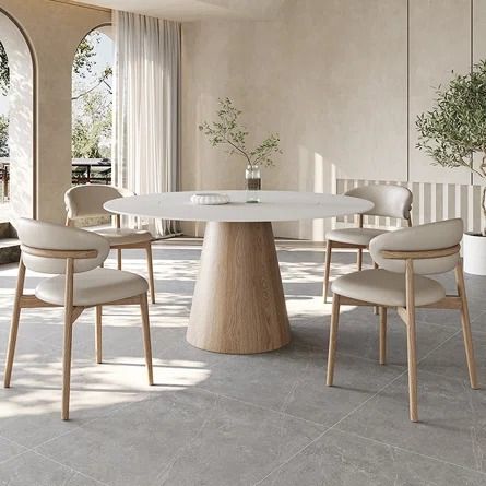 a white table with four chairs around it in a room that has large windows and arched doorways