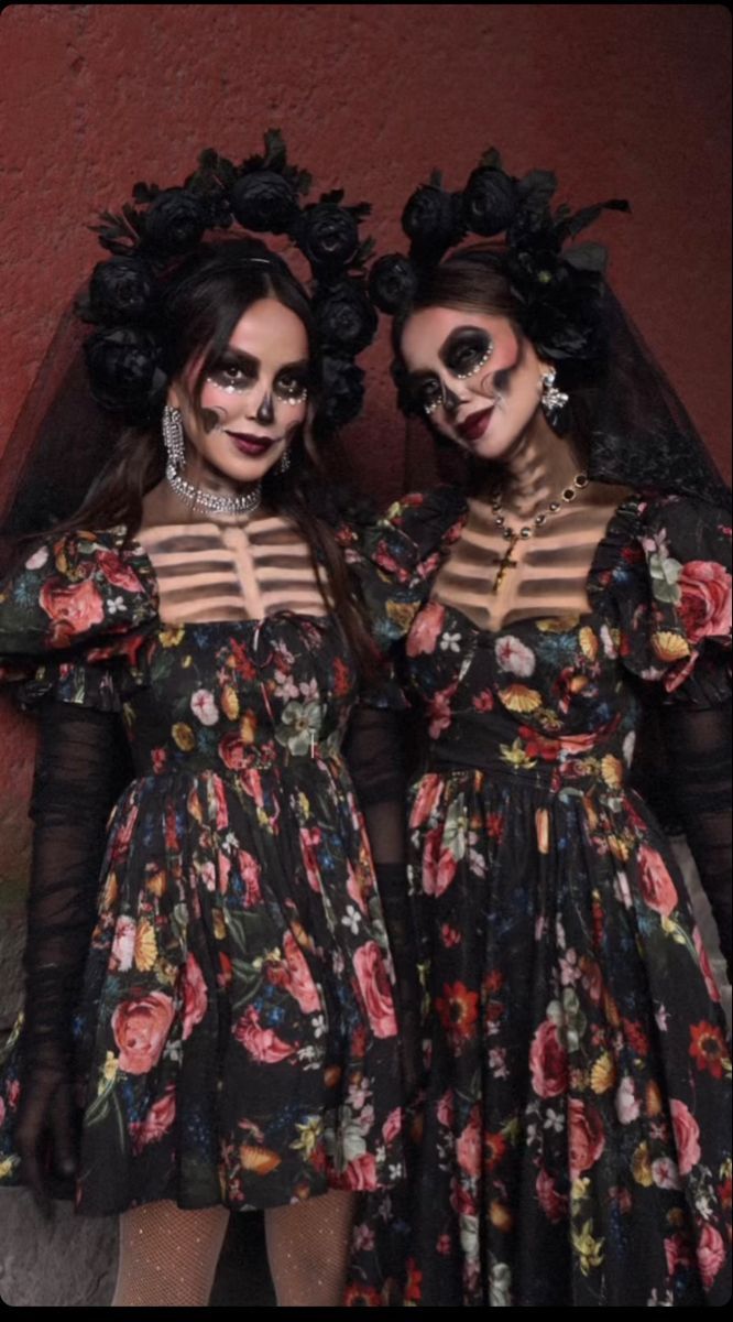 two women dressed in skeleton makeup are standing next to each other