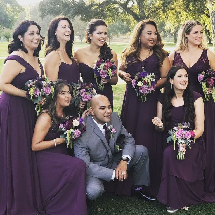 a group of bridesmaids in purple dresses posing for a photo with their groom