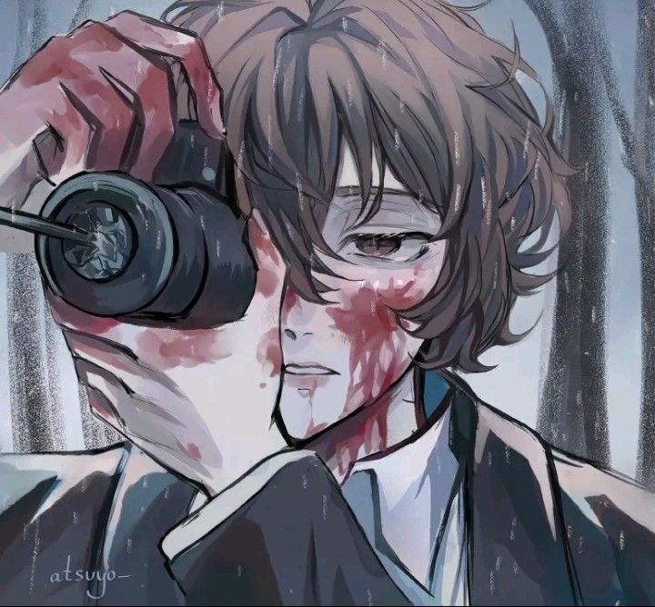 a man holding a camera in front of his face with blood on the wall behind him