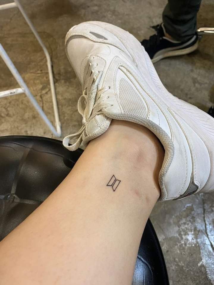 a woman's foot with a small tattoo on her left ankle and the letter d