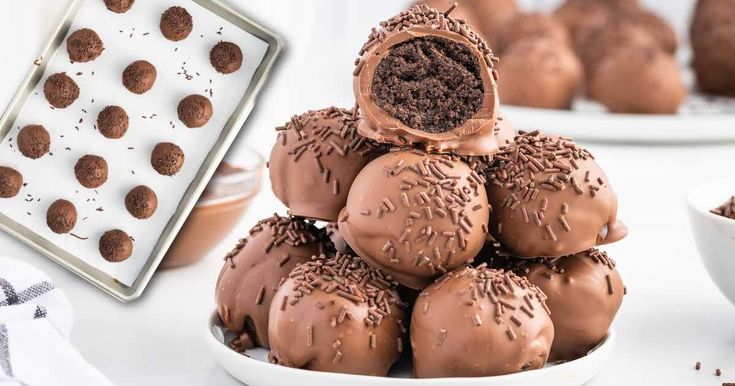 chocolate truffles stacked on top of each other in front of a plate of cookies