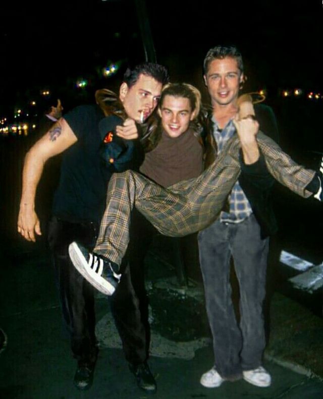 two men and a woman posing for the camera with their arms around each other in front of them