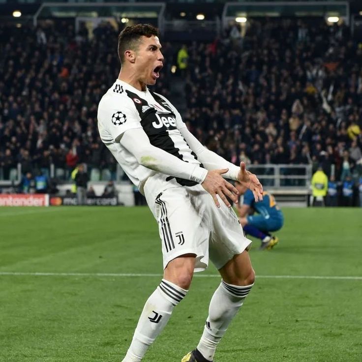 a soccer player celebrates his goal in front of an audience at a sporting event,