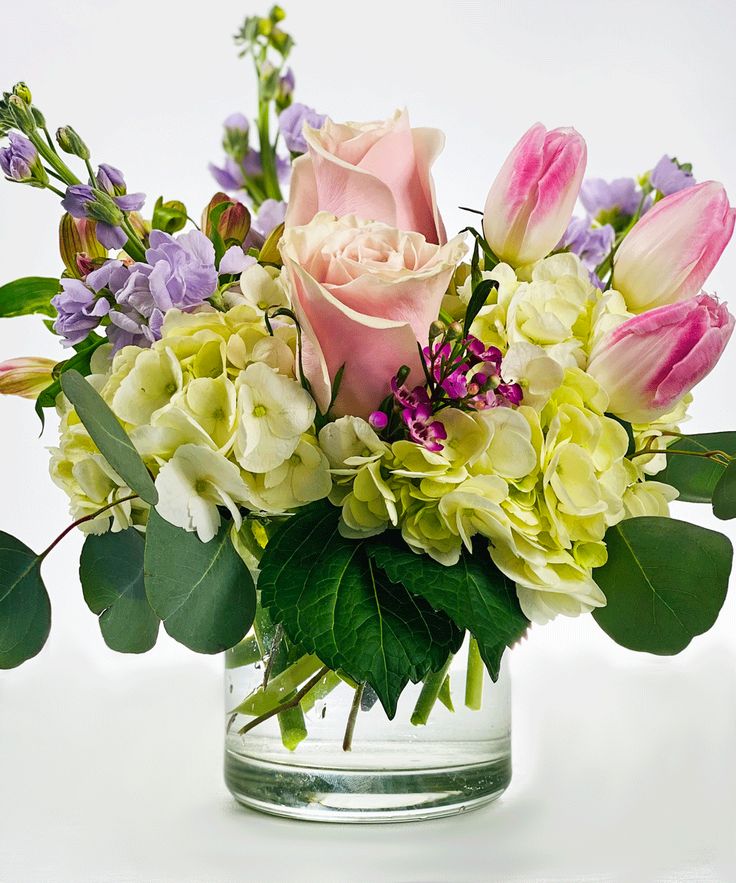 a vase filled with lots of flowers on top of a table