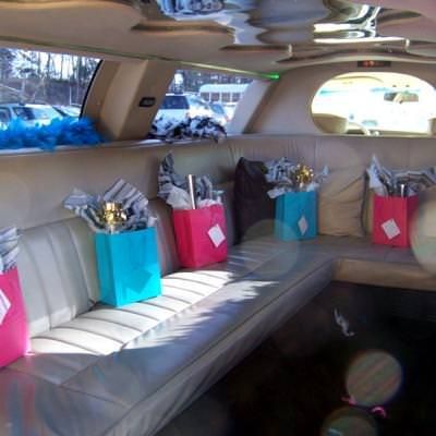 the inside of a car with several bags on the back seat and flowers in vases