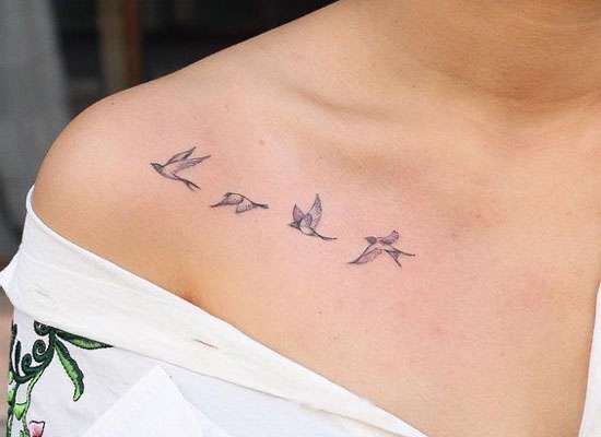 a woman's chest with three birds on it