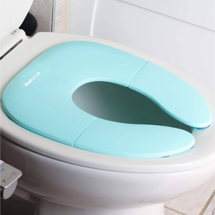 a toilet seat with the lid open and an electronic device attached to it's side