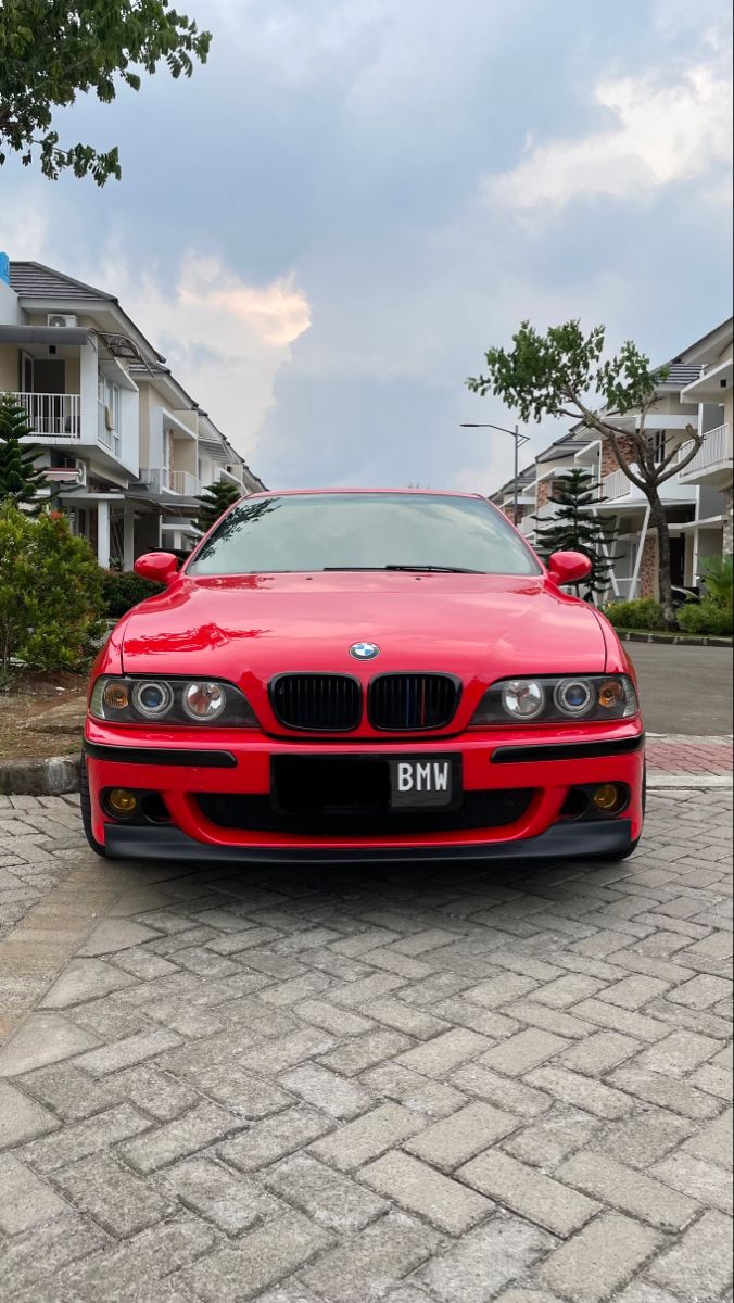 a red car parked in front of some houses