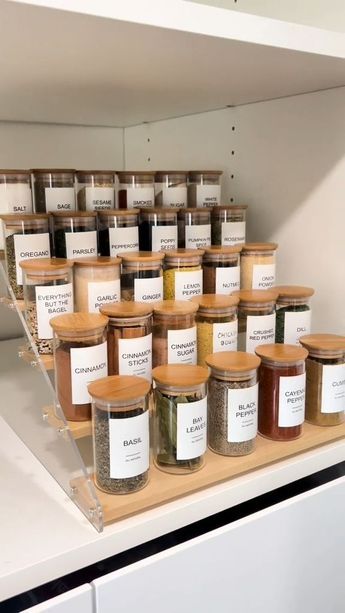 many jars of spices on a shelf in a kitchen