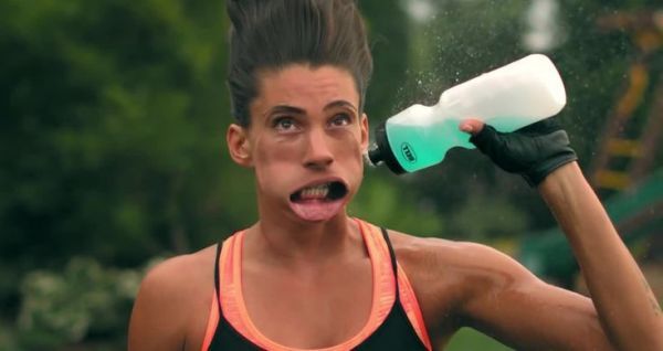 a woman with her mouth open holding a hair dryer in one hand and an empty bottle in the other