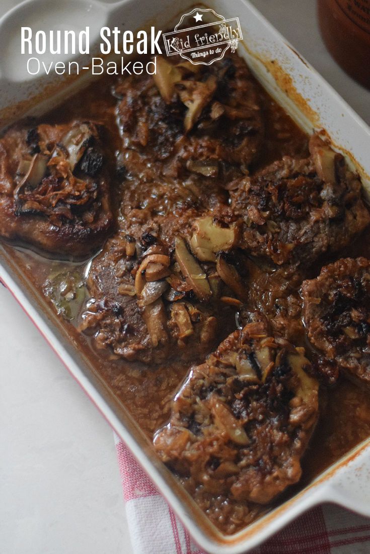 cooked meat in gravy on top of a baking dish with mushrooms and onions