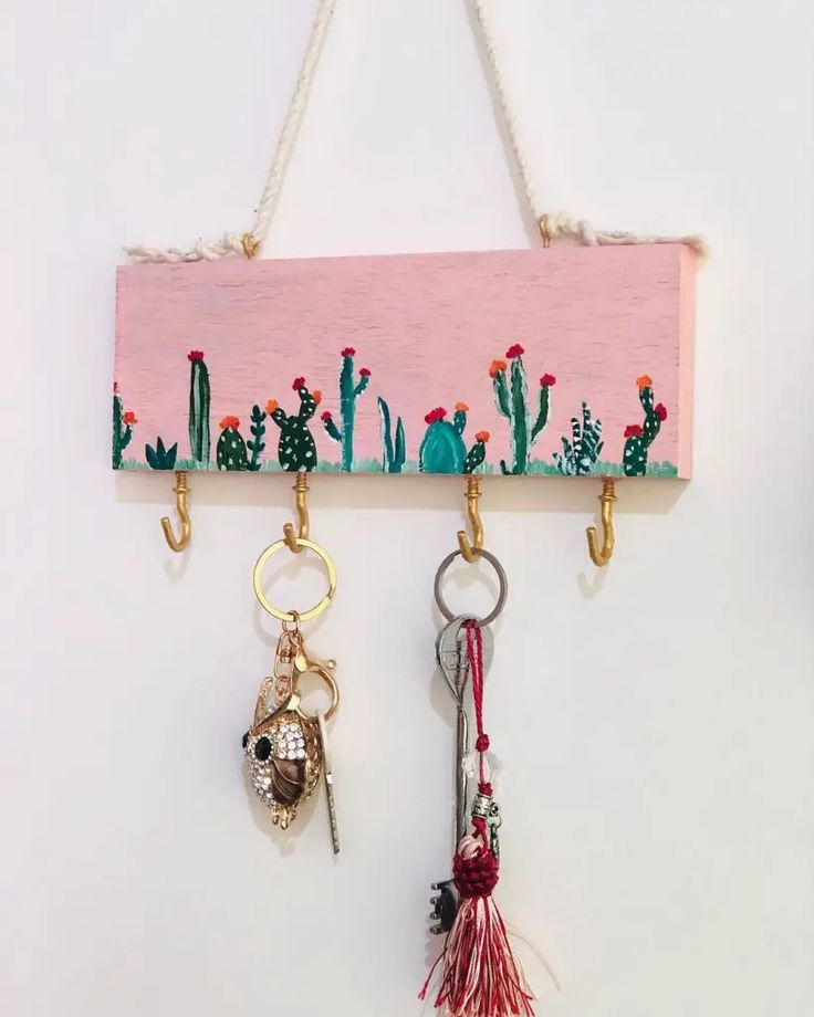 three key chains hanging on a wall with cactus and cacti painted on them