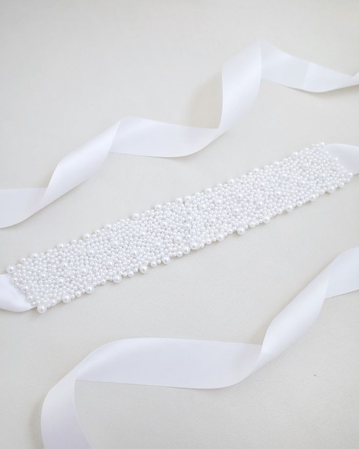 A statement sash is encrusted with beautiful pearls attached on bridal white double-faced satin ribbon. This classic pearly belts creates a romantic finishing touch to your bridal gown, bridesmaids and flower girls, or as hair accessories. DETAIL:Adult Size 108"Kids Size 78"Applique size: 12" length, 2" wideHANDMADE IN USAIMPORTED MATERIALS Pearl White Pearl Bridal Accessories, Elegant Ribbon Bridal Belt For Wedding, White Beaded Sashes For Party, Elegant Pearl Embellished Sashes For Party, Elegant White Sash For Mother Of The Bride, Elegant Satin Bridal Accessories For Wedding, Elegant White Sashes For Mother Of The Bride, Elegant Beaded Bridal Belt For Party, Formal Adjustable Bridal Belt With Sashes