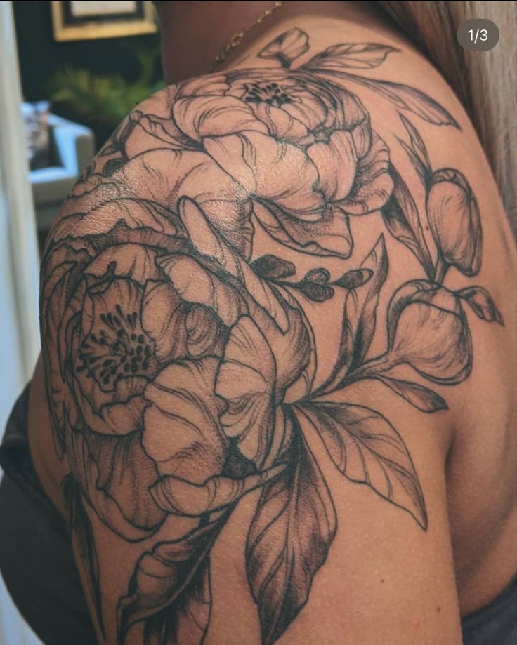 a woman's shoulder with flowers and leaves on it