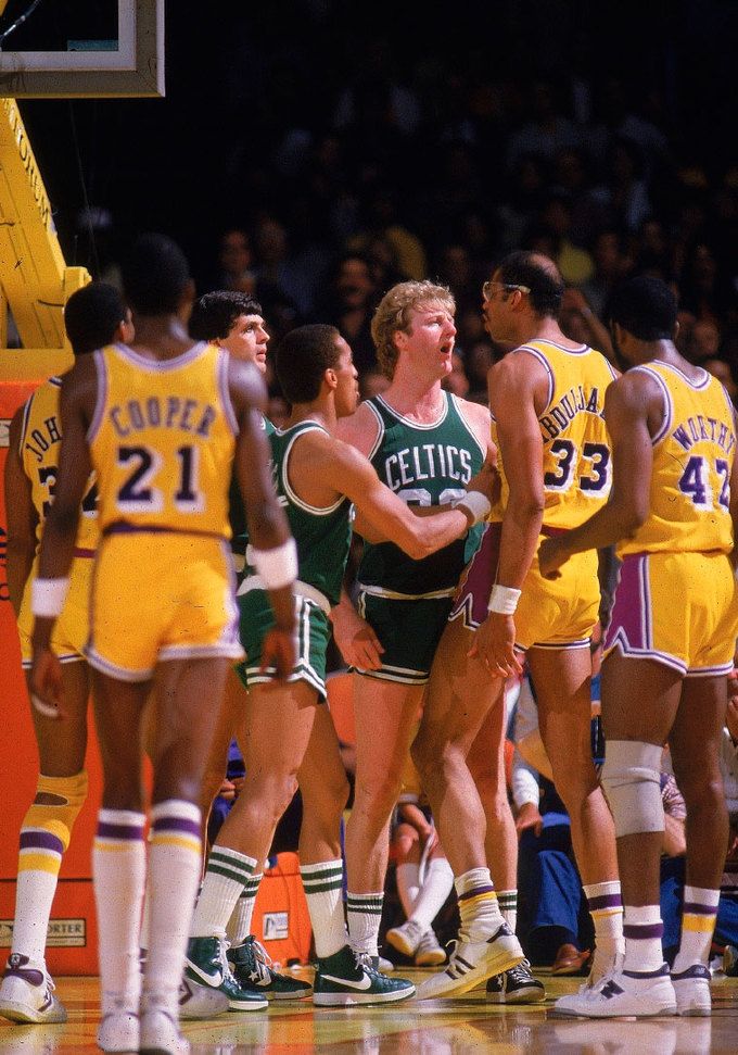 a group of men standing on top of a basketball court