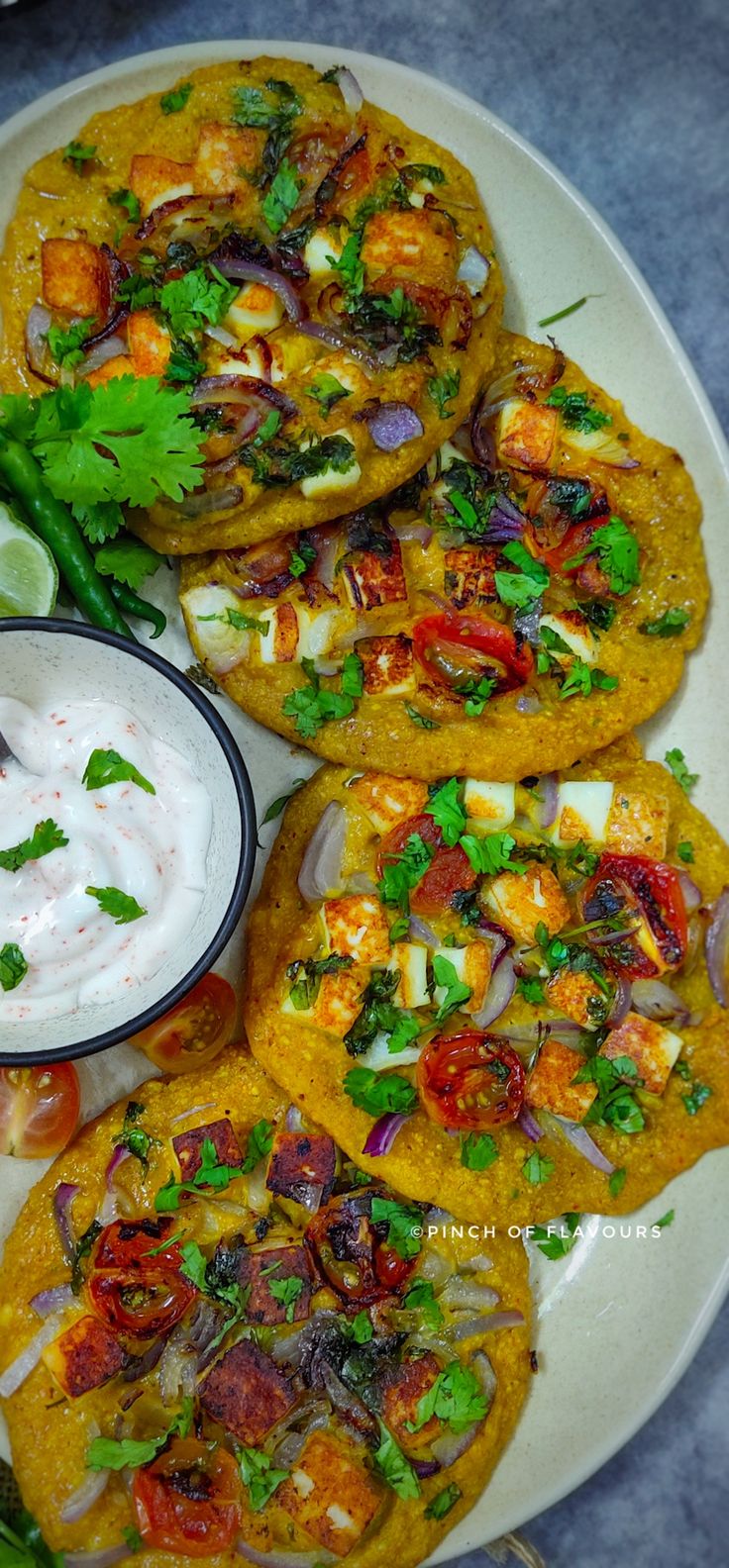 several tortillas on a white plate topped with sour cream and garnish