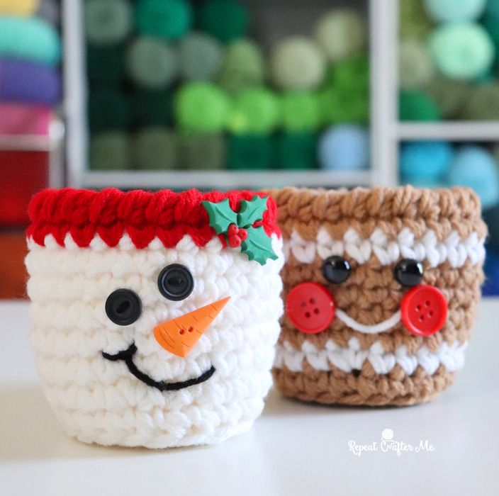 two crocheted mugs with faces made to look like snowmen