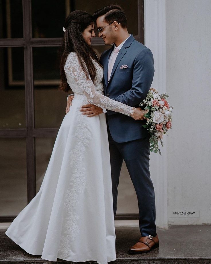 a bride and groom standing together in front of a building