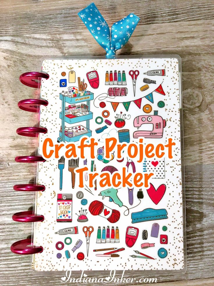 the craft project tracker book is open on a wooden table with red markers and blue ribbon