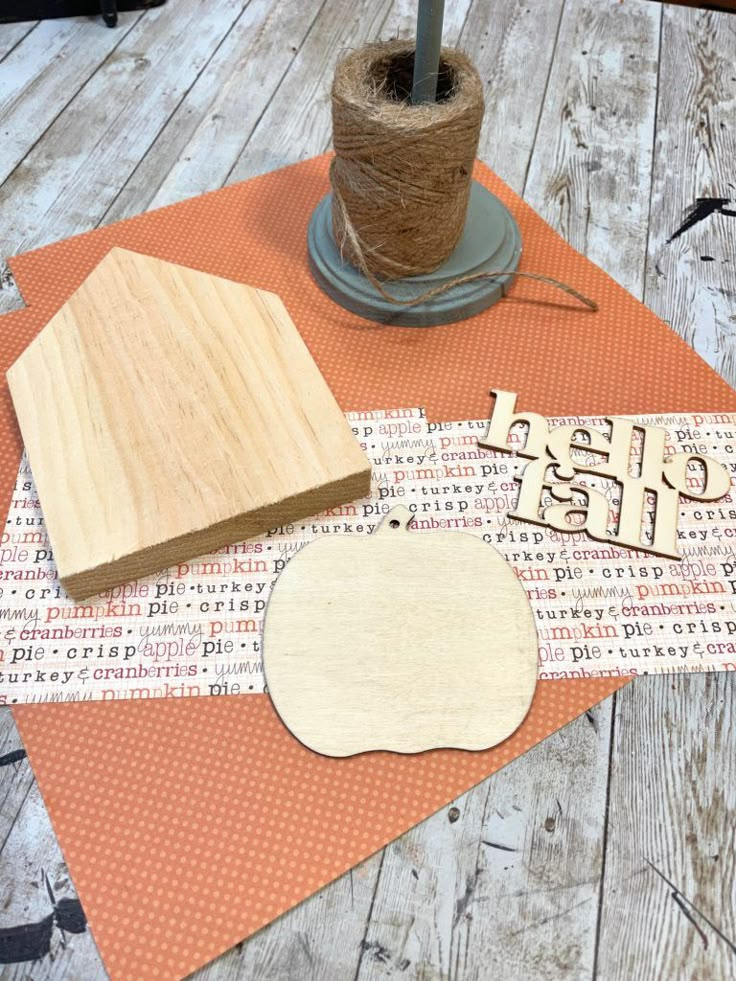 some crafting supplies are laying out on a table top, including wood and paper