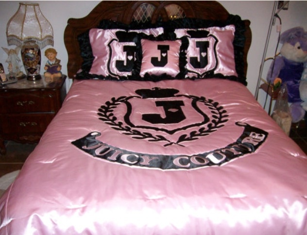 a bed with a pink comforter and black pillows