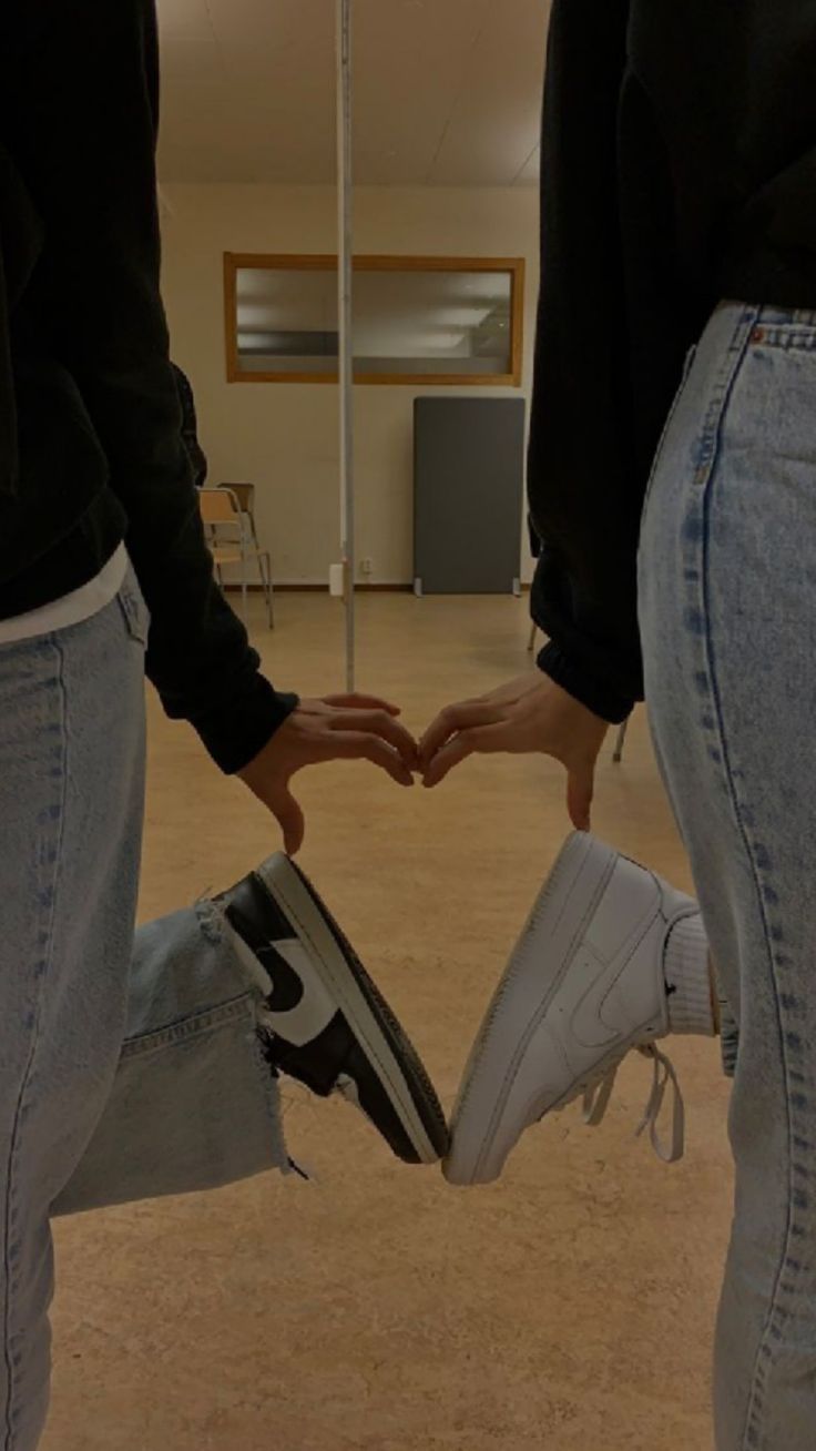 two people holding hands in the shape of a heart