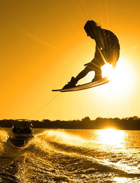 a man flying through the air while riding a wake board