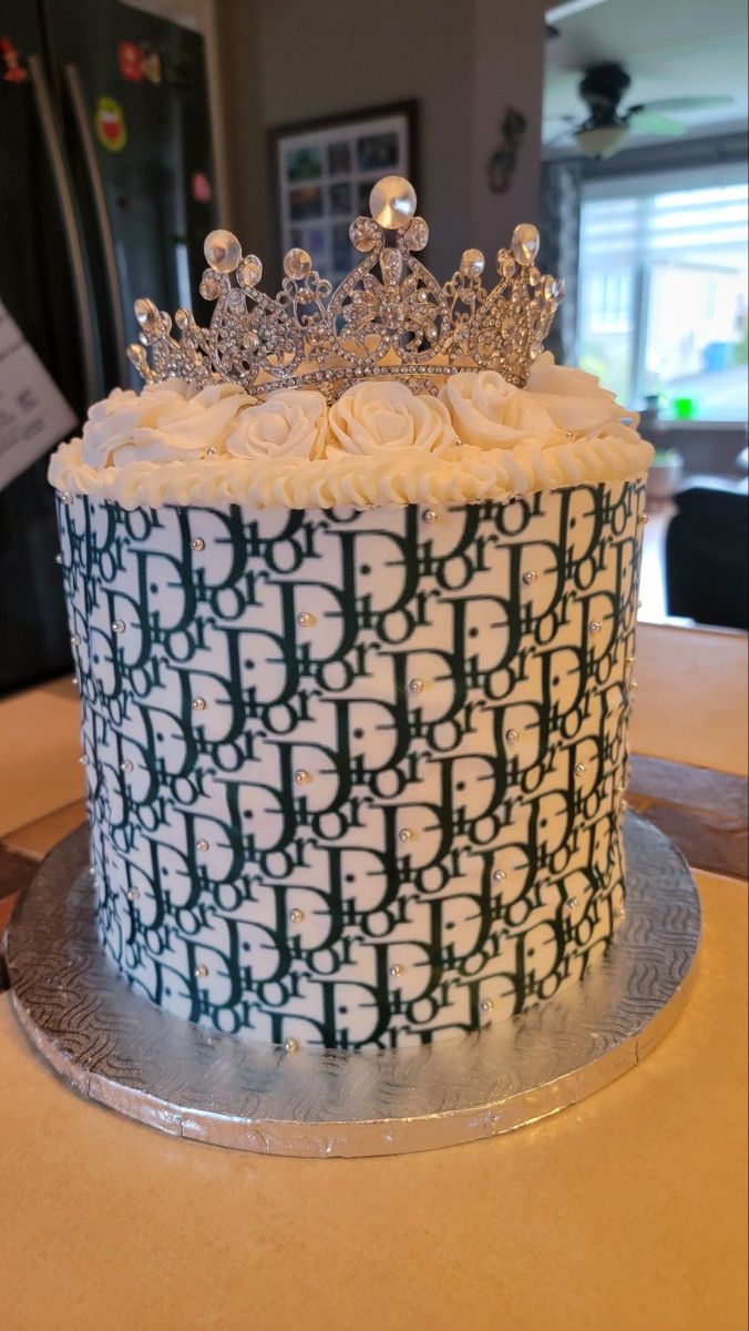 a cake with white frosting and a crown on top is sitting on a table