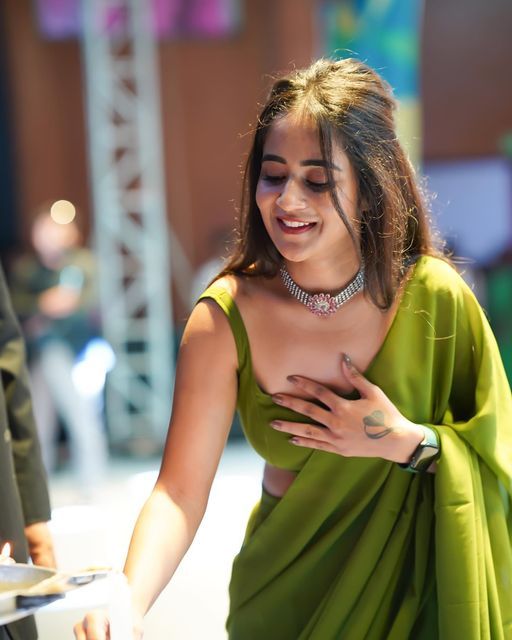 a woman in a green dress looking at her cell phone