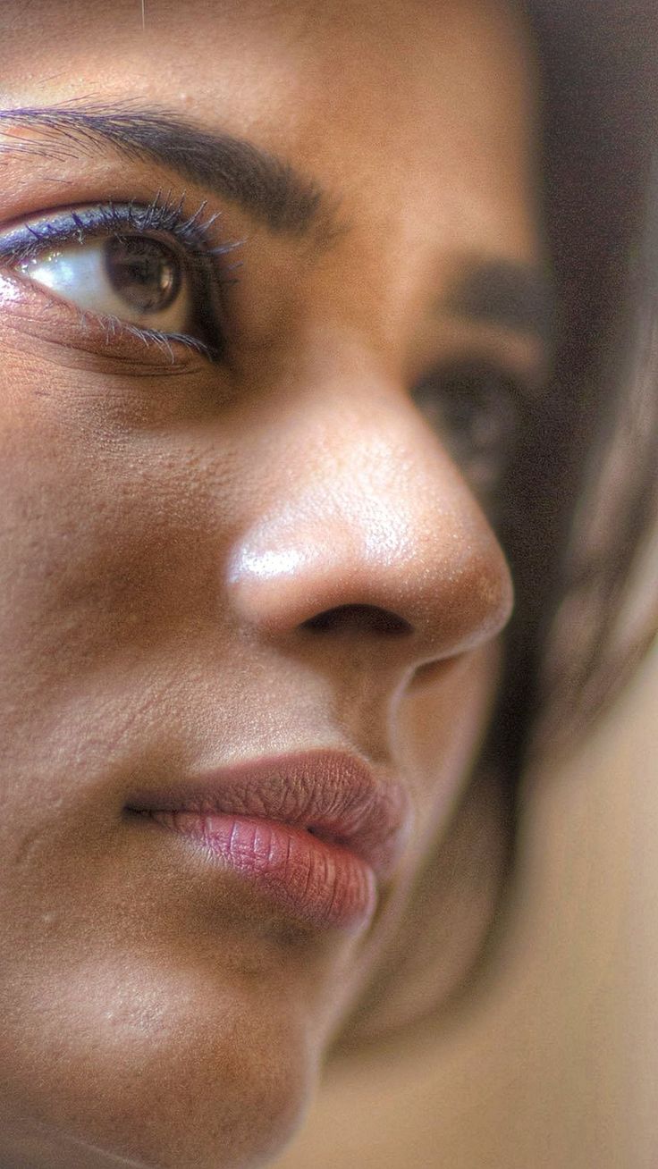 a close up of a woman's face with blue eyes