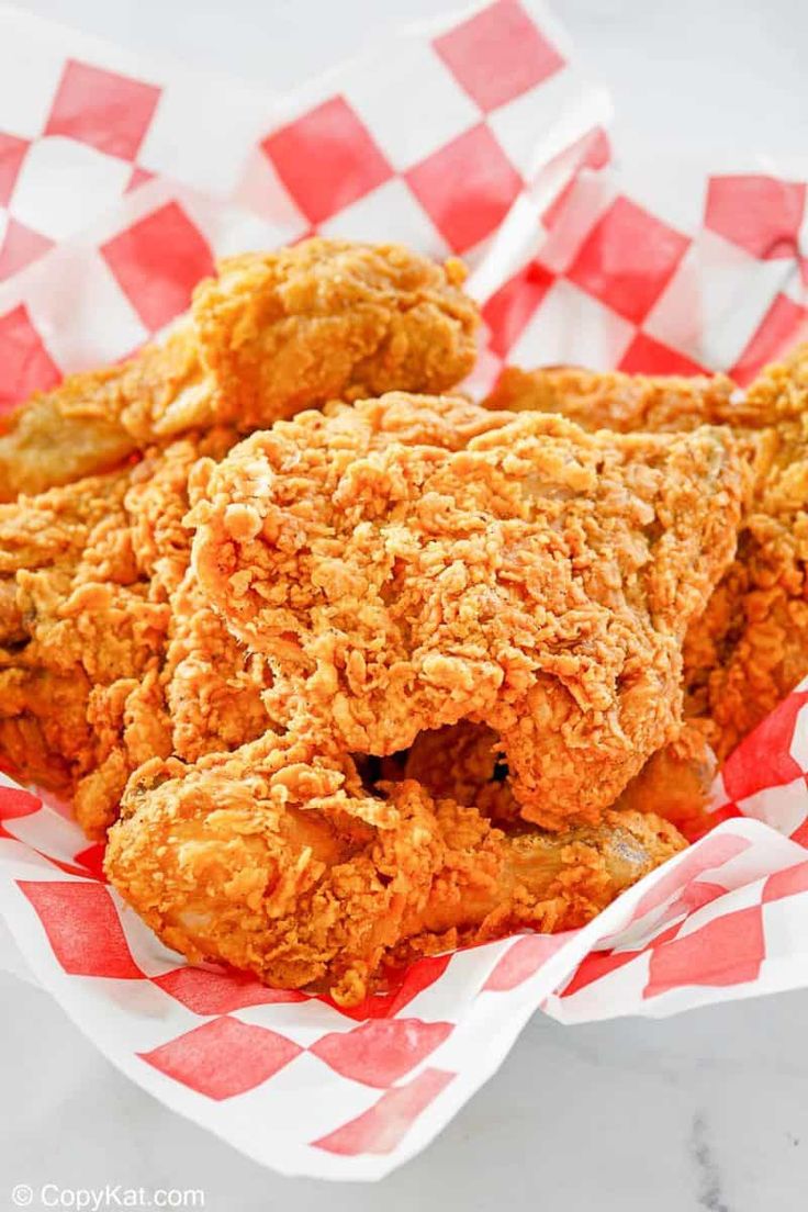 fried chicken in a basket with red and white checkered paper