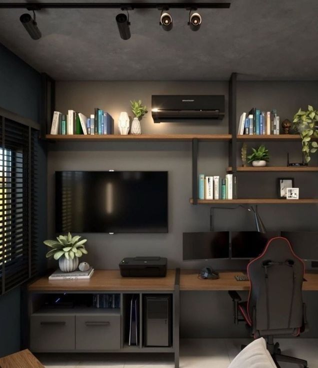 a living room with a desk, television and bookshelves on the wall in front of it