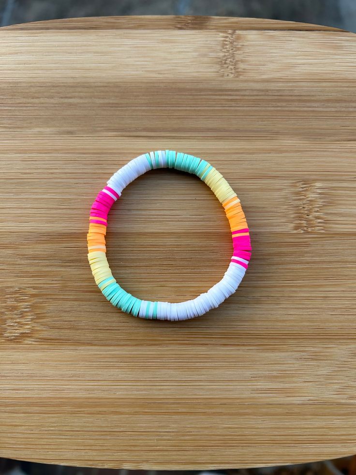 a colorful bracelet sitting on top of a wooden table