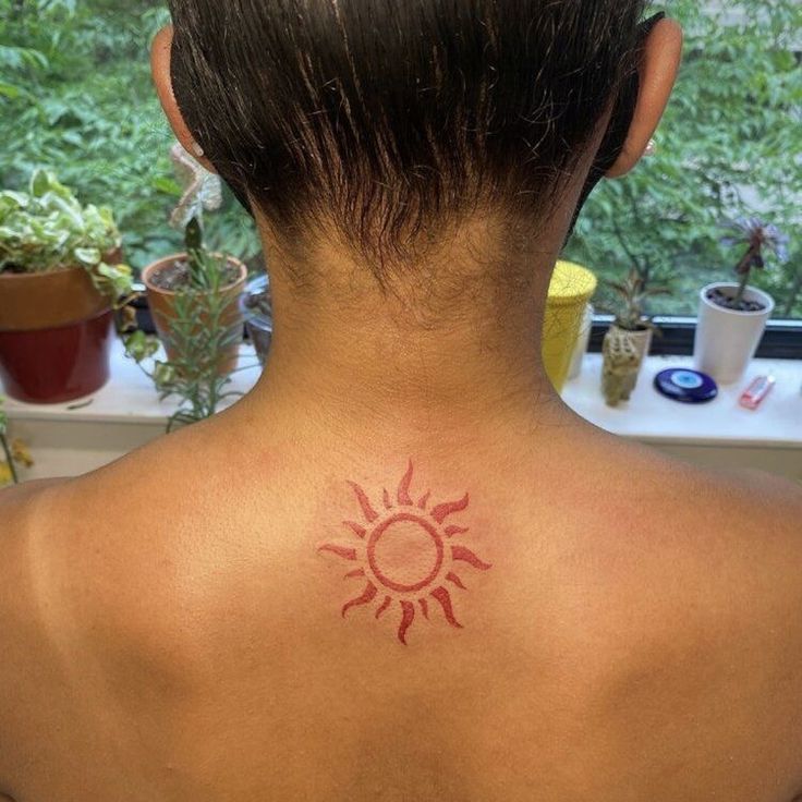 a woman with a sun tattoo on her back