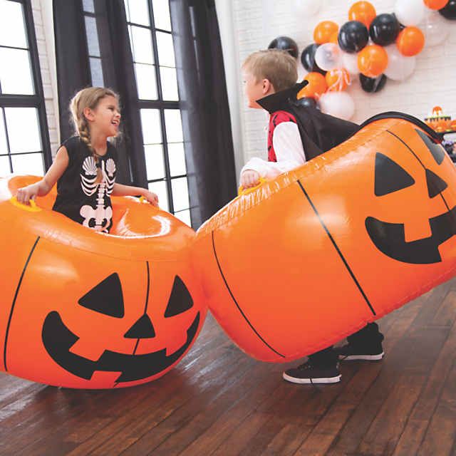 two children playing with inflatable pumpkins