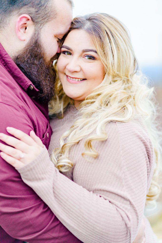 a beautiful blonde woman hugging a bearded man