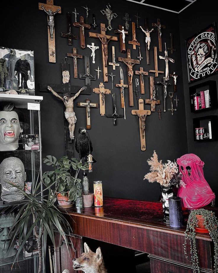 a room with many crosses on the wall and various items in front of it, including a dog