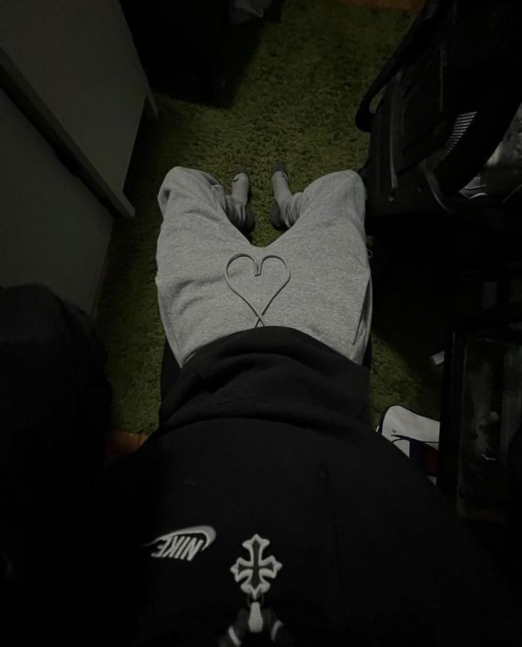 a person laying on the ground with their feet up in front of them, wearing a hoodie