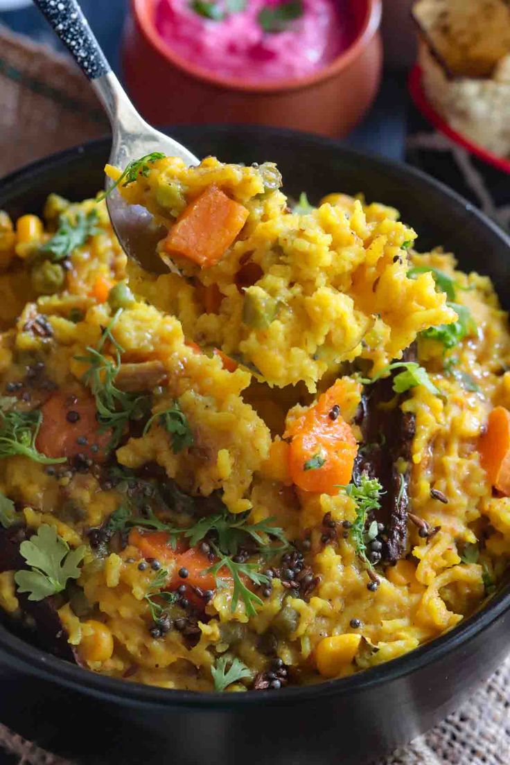 a bowl filled with rice and carrots on top of a table