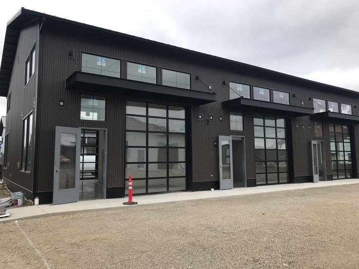 a large black building with lots of windows and doors on the side of it's sides