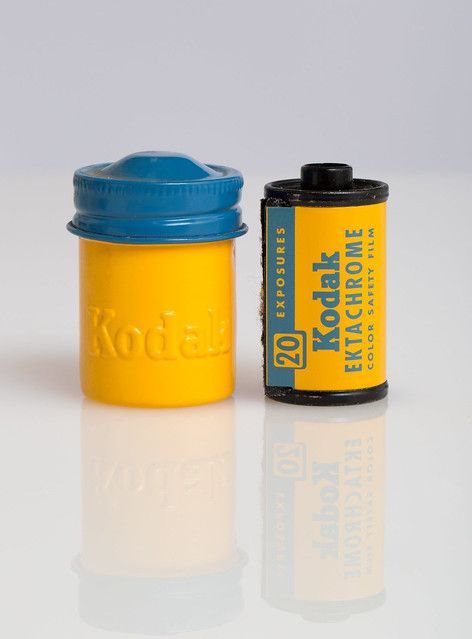 a yellow and blue canister sitting next to each other on a white table top