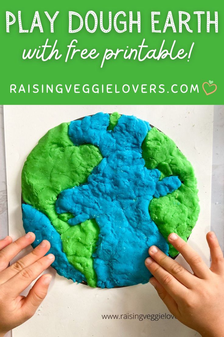 two hands holding up a play dough earth with free printable for kids to make