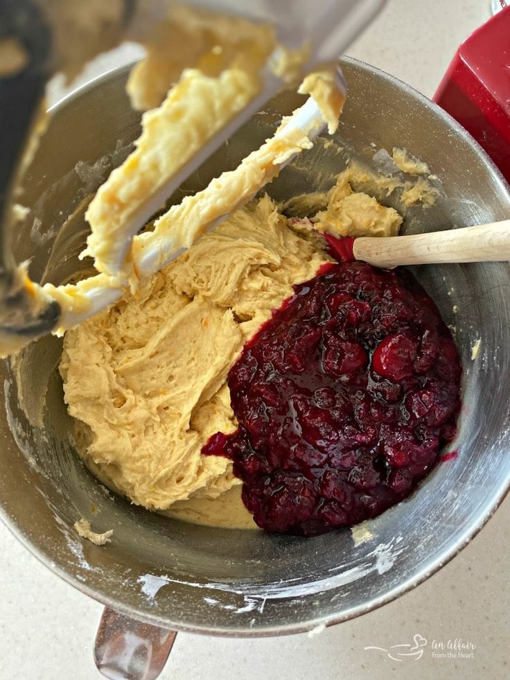 a mixing bowl filled with batter and cranberry sauce