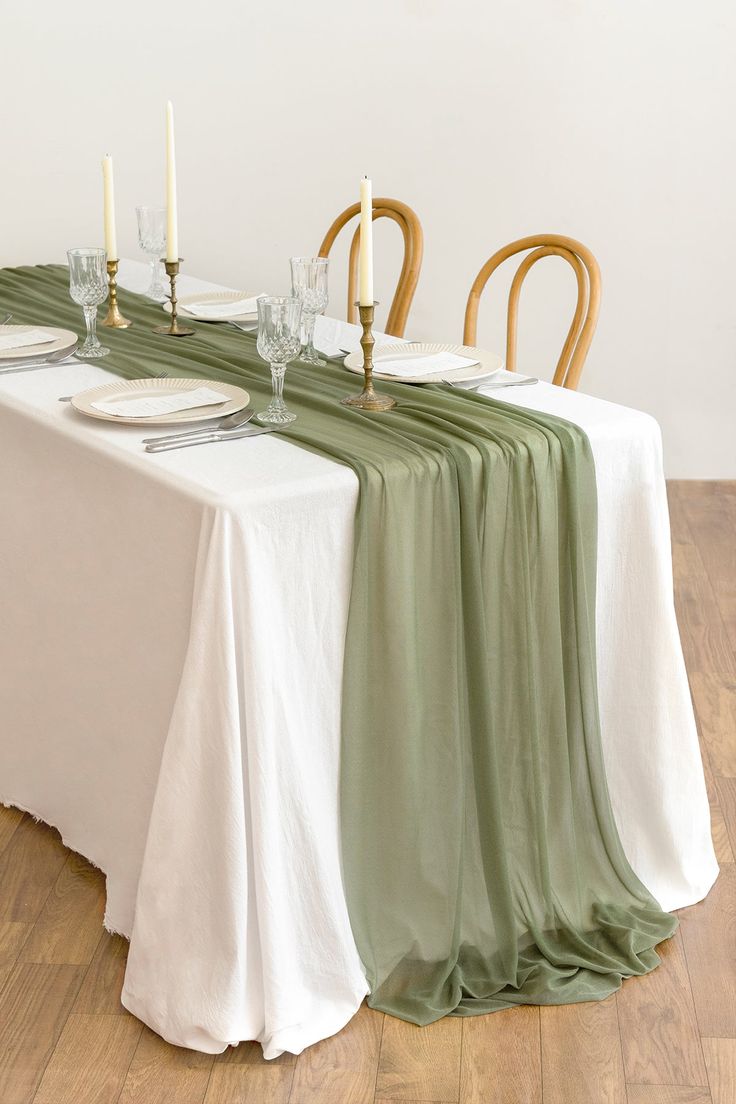 the table is set with white and green linens